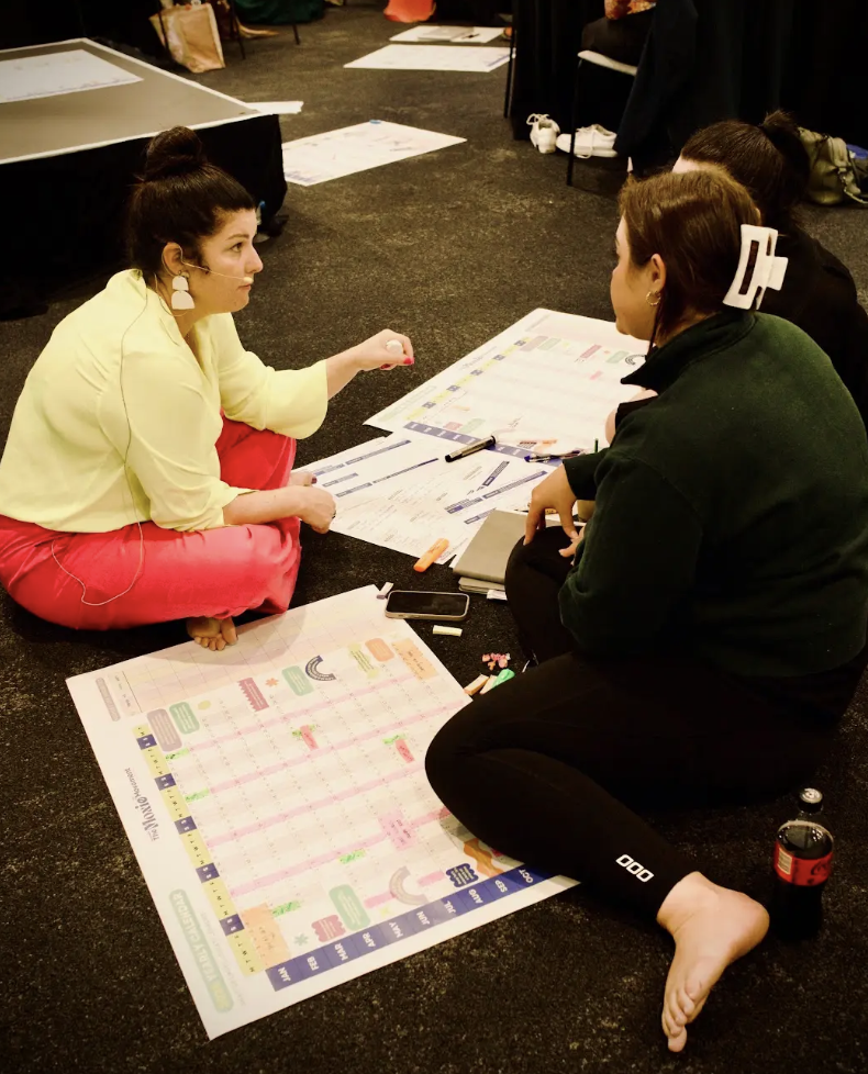 Moxie members mapping out their business plans together on the floor