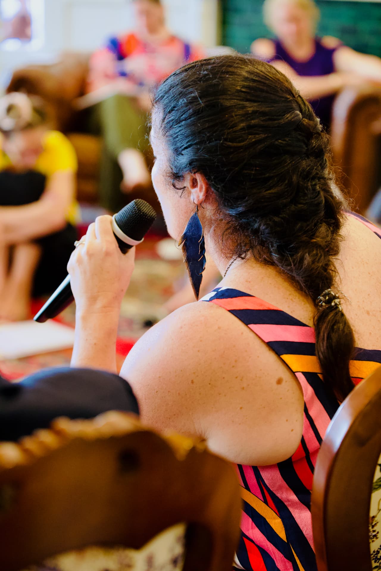 Woman speaking into a microphone during a retreat celebration session