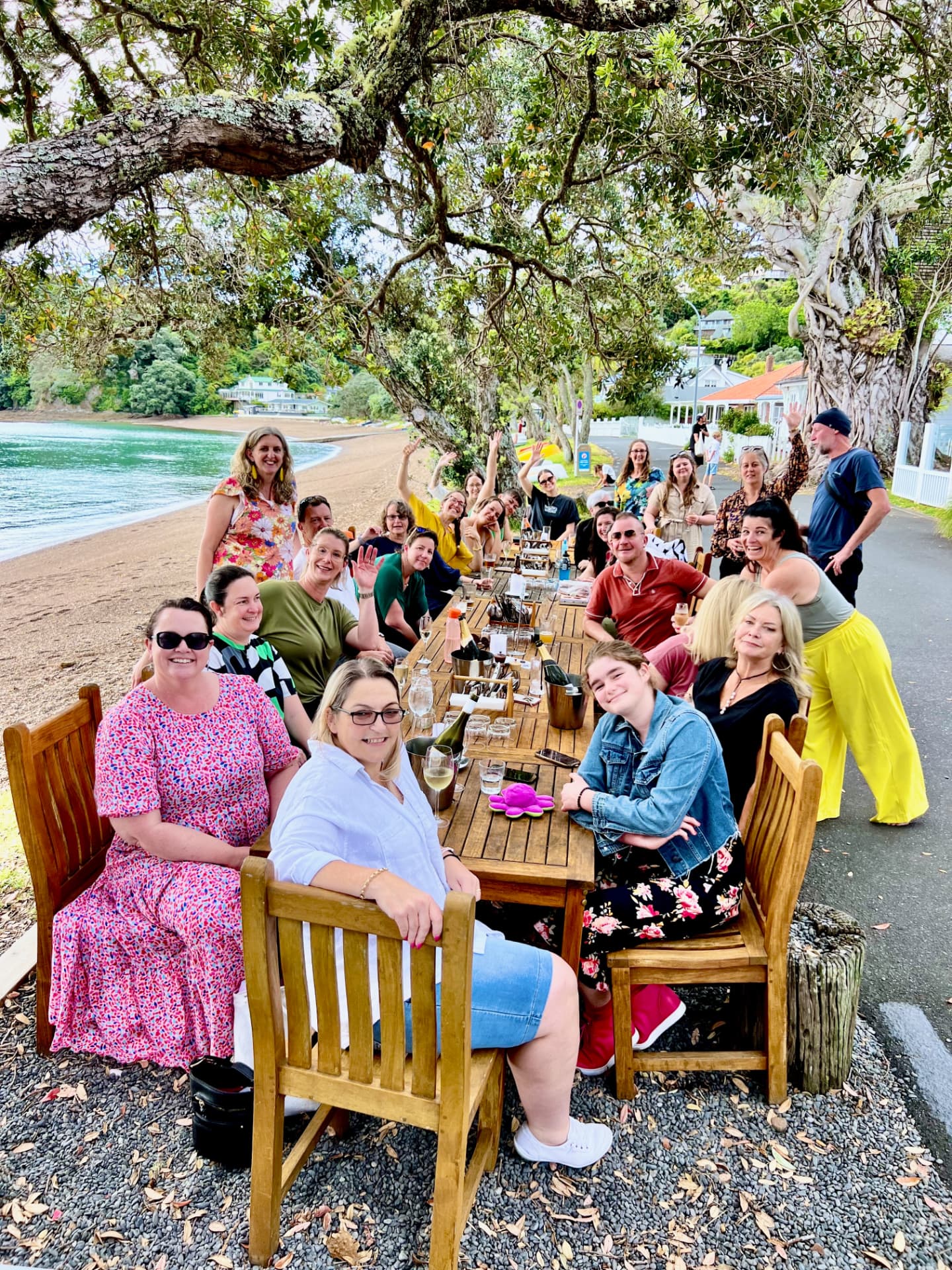 Moxie members celebrating together at a long table by the beach