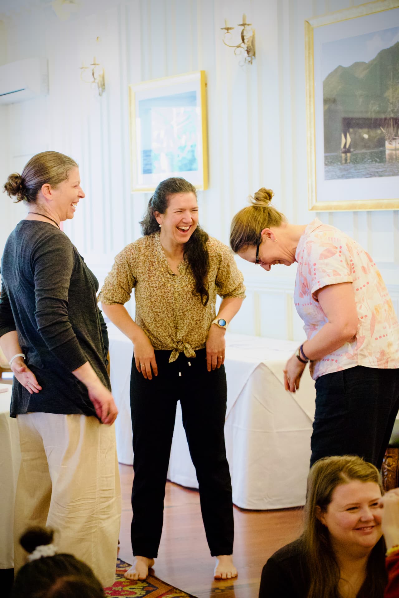 Three attendees laughing together during a workshop exercise