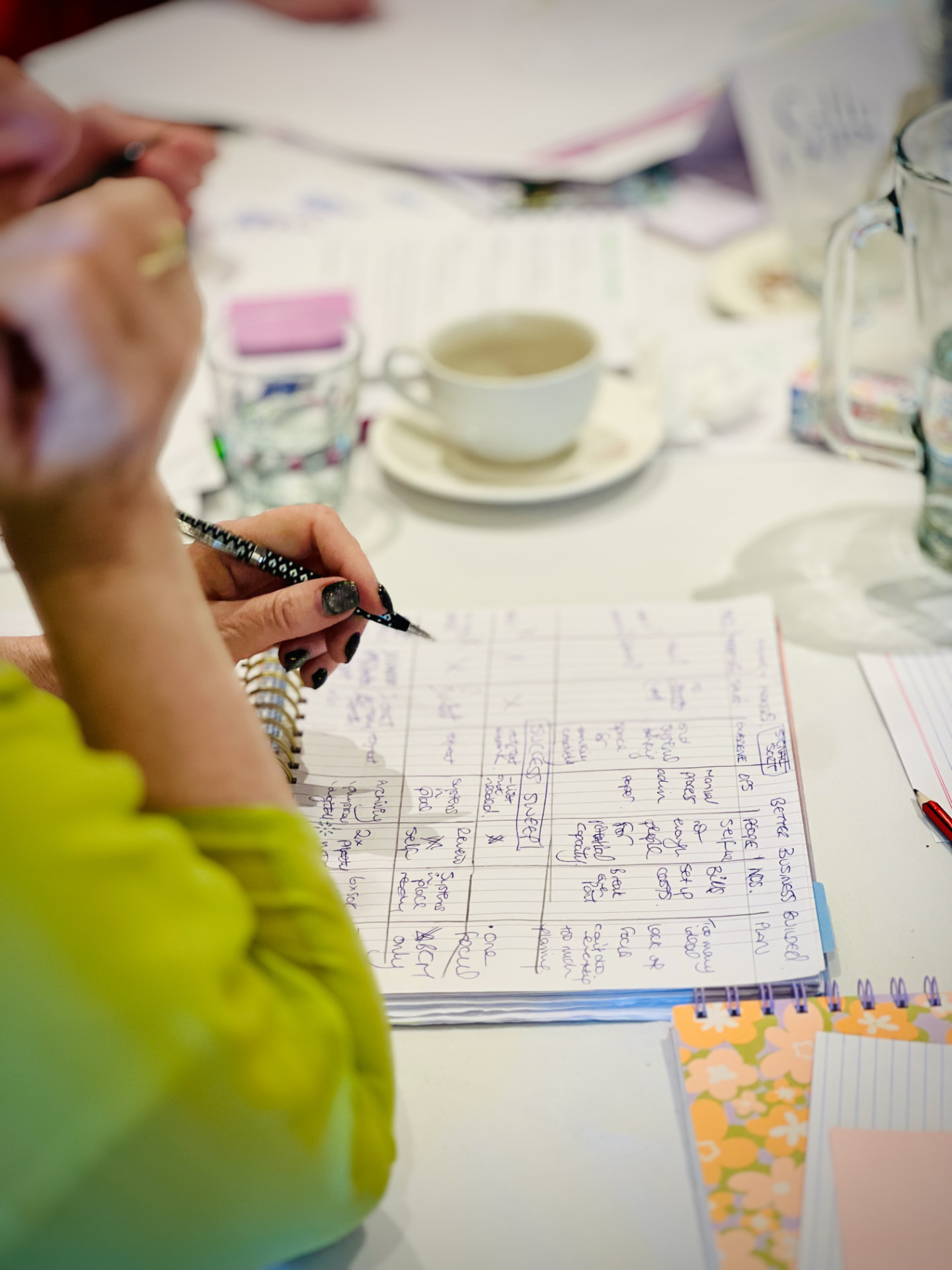 Attendee writing her business plan in a workbook at the retreat table