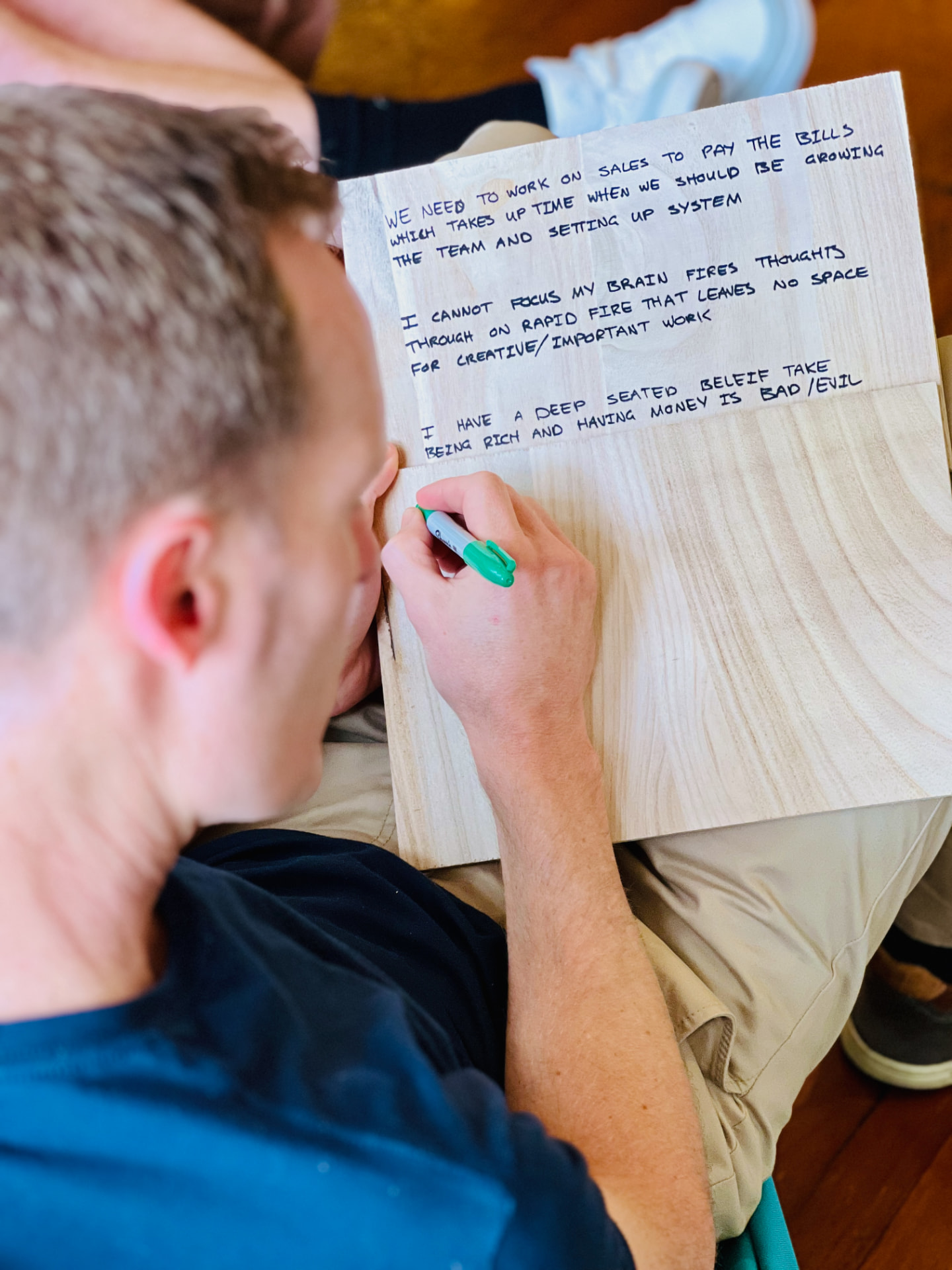Attendee writing a business plan at a workshop table during a virtual retreat session