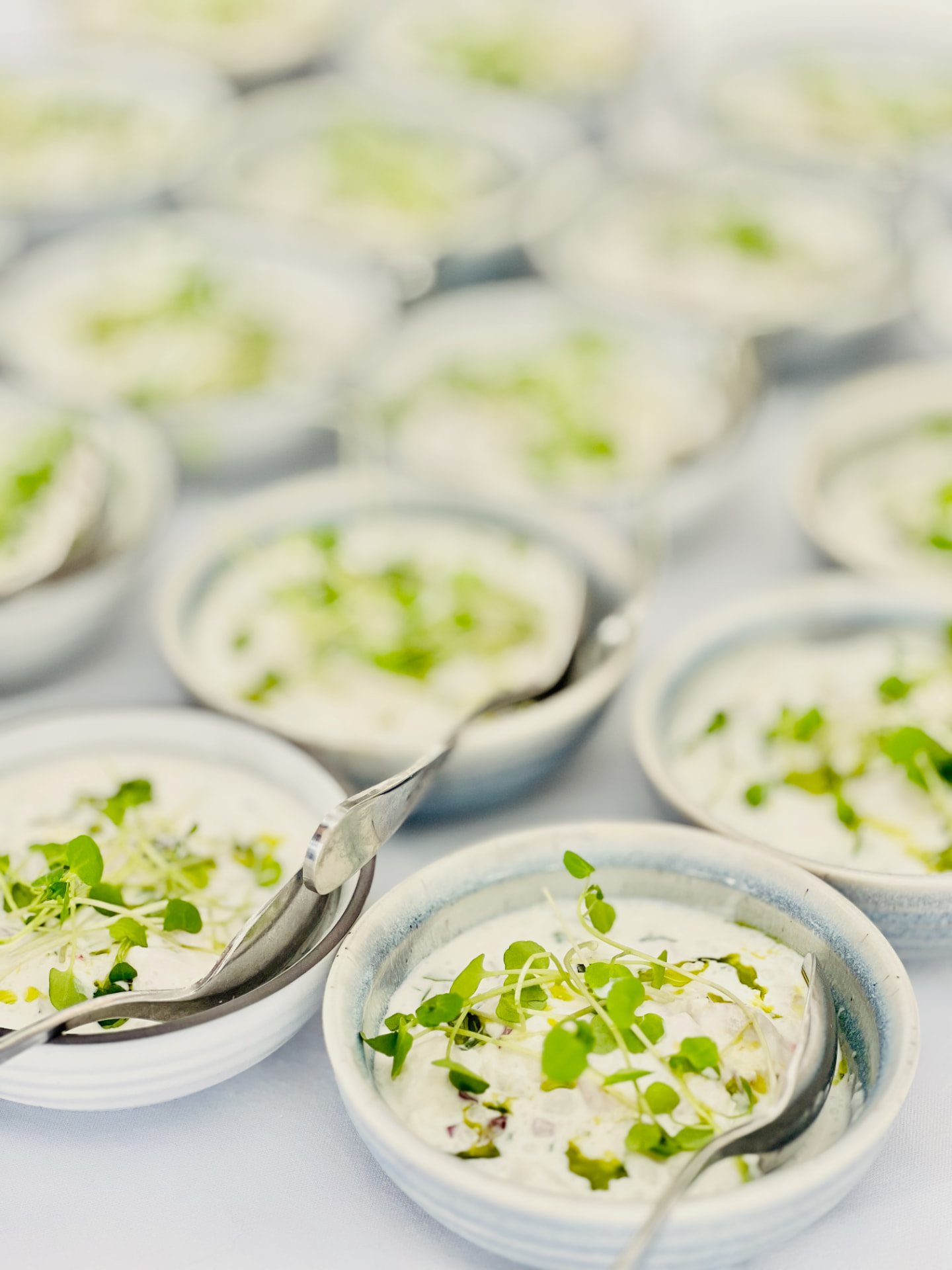 Small ceramic bowls of seafood served with micro greens